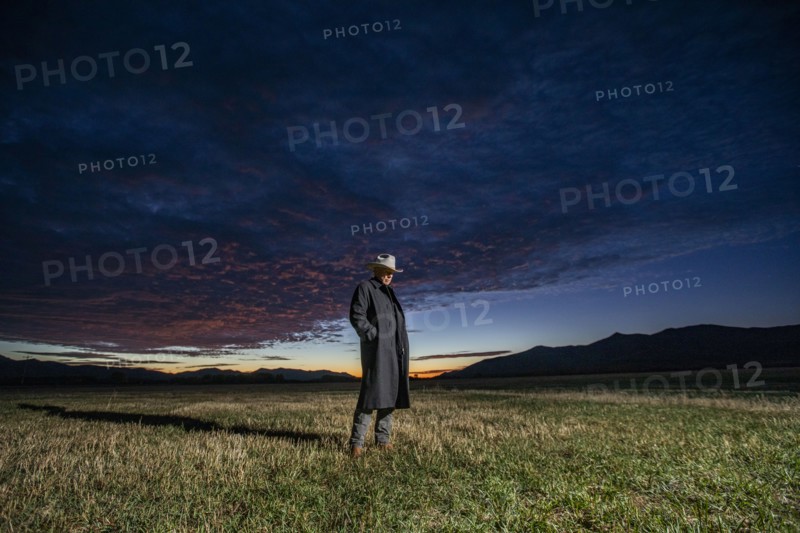 USA, Idaho, Bellevue, Rancher in overcoat standing in field at sunrise, Bellevue, Idaho, USA