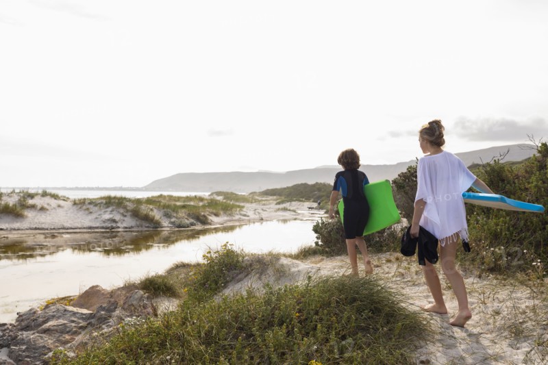 South Africa, Hermanus, Brother and sister walking on beach with body boards, Hermanus, , South Africa