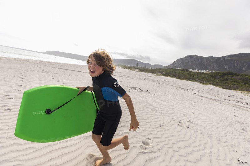 South Africa, Hermanus, Smiling boy running on beach with body board, Hermanus, , South Africa