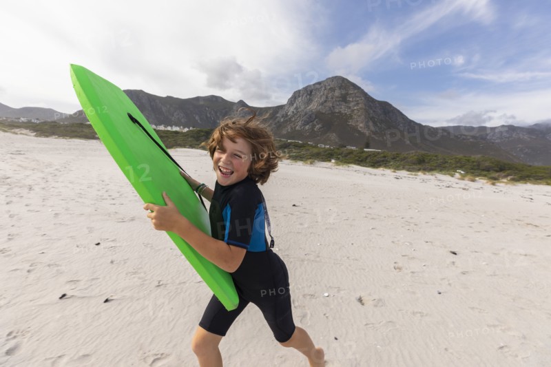 South Africa, Hermanus, Smiling boy running on beach with body board, Hermanus, , South Africa