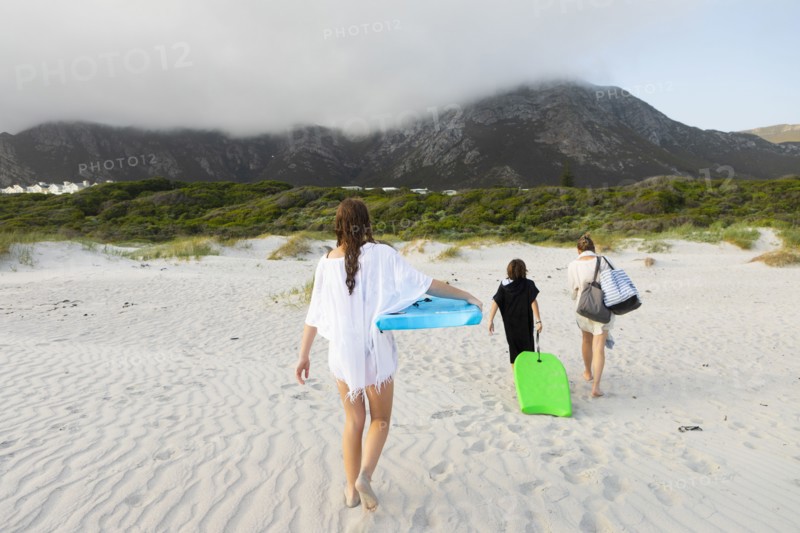 South Africa, Hermanus, Rear view of family walking on beach, Hermanus, , South Africa