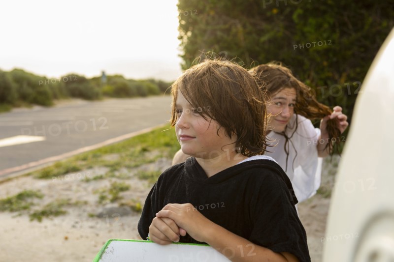 South Africa, Hermanus, Portrait of boy with surfboard and sister on beach, Hermanus, , South Africa