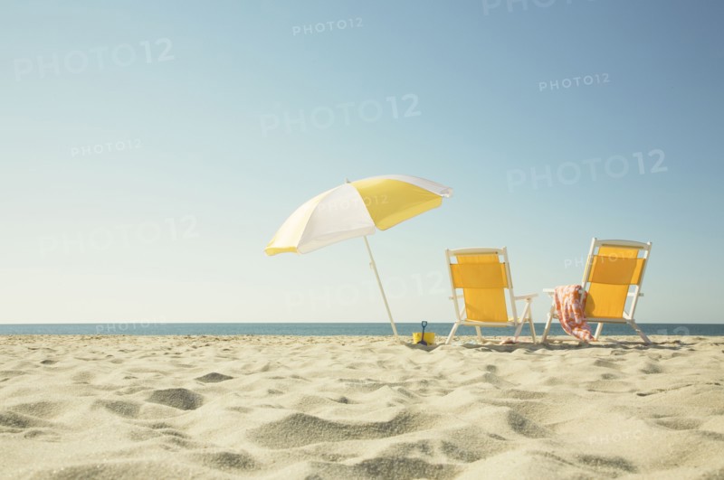 USA, Massachusetts, Nantucket, Two yellow beach chairs and umbrella on sandy beach facing ocean, Nantucket, Massachusetts, USA