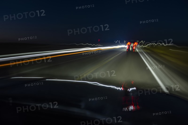 Highway at night seen from moving vehicle, blurred motion, Twin Falls, Idaho, USA