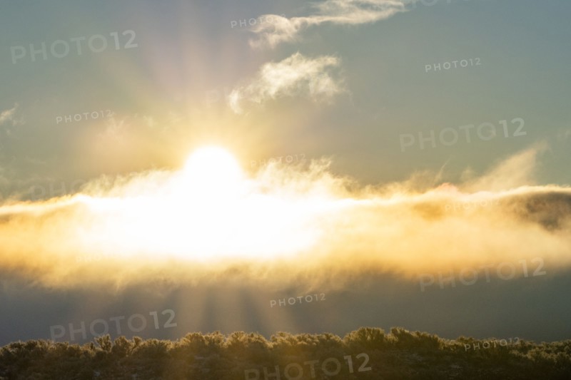 Morning sun bursting through cloudbank, Picabo, Idaho, USA