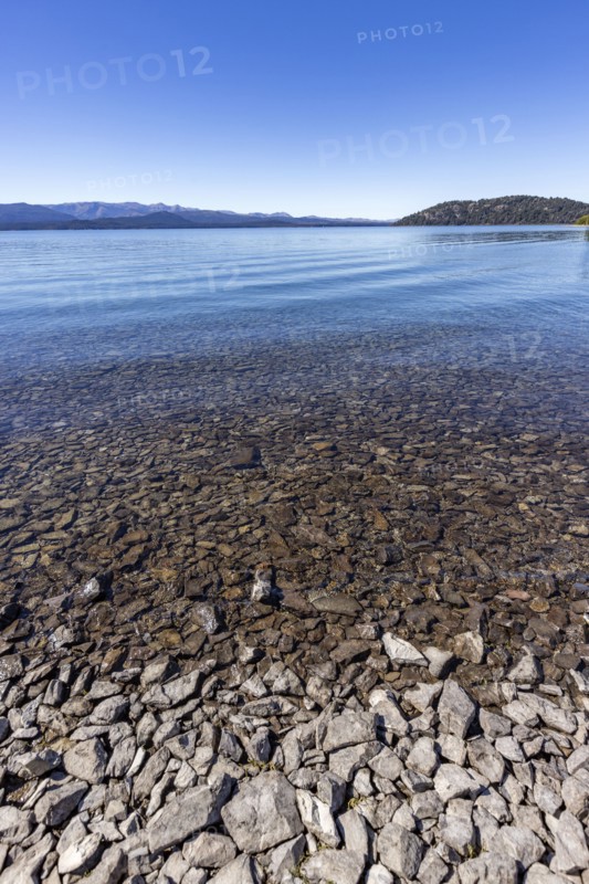 Rocky beach and calm lake on sunny day, Bariloche, , Argentina