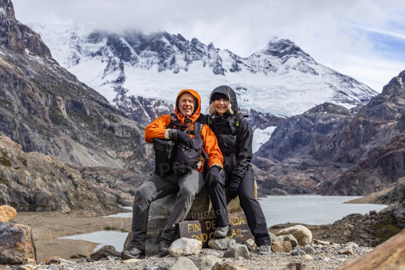 Argentina, Santa Cruz, El Chalten, Portrait of smiling hikers sitting at trails end below Marconi Glacier, El Chalten, Santa Cruz, Argentina