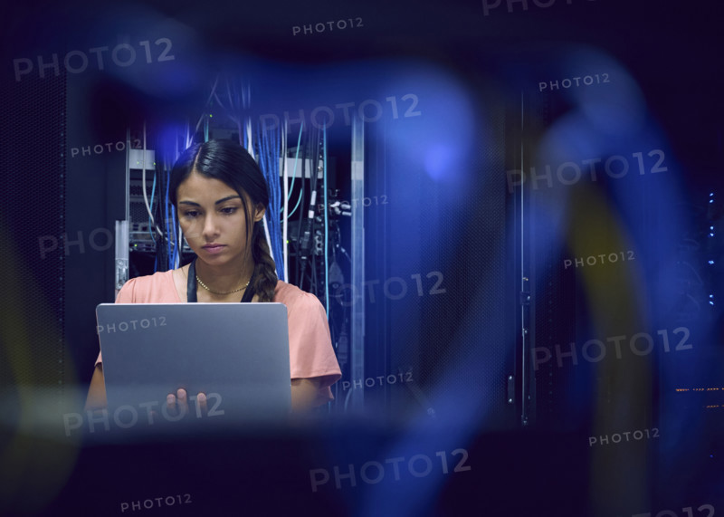 Female technician using laptop in server room 
St, George, Utah, USA