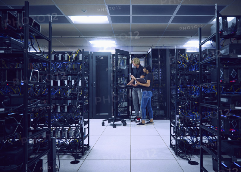 Technicians using computer in server room 
St, George, Utah, USA