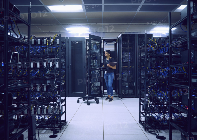 Female technician using computer in server room 
St, George, Utah, USA