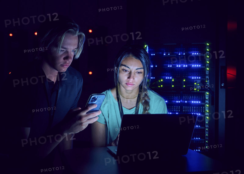 Female and male technicians using laptop in server room 
St, George, Utah, USA