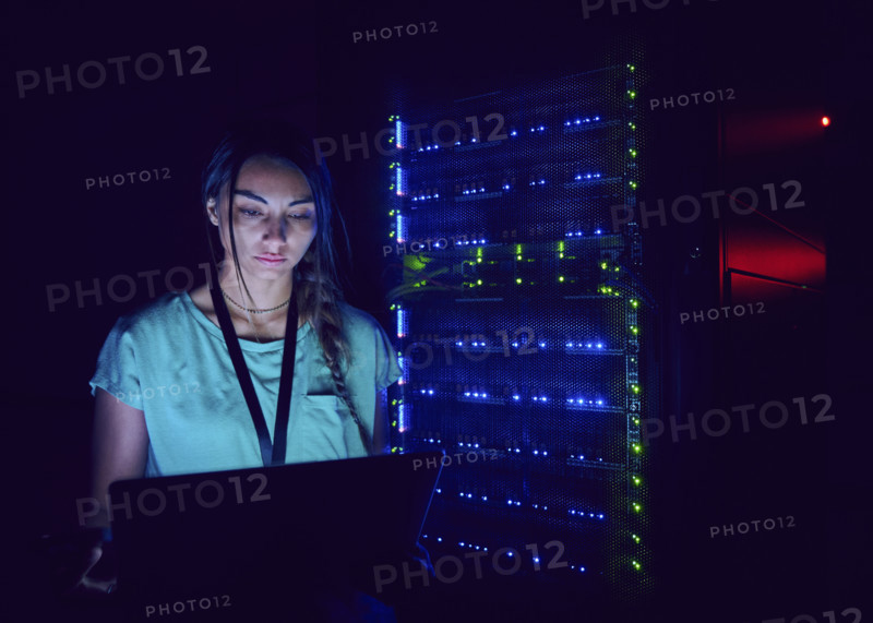 Female technician using laptop in server room 
St, George, Utah, USA