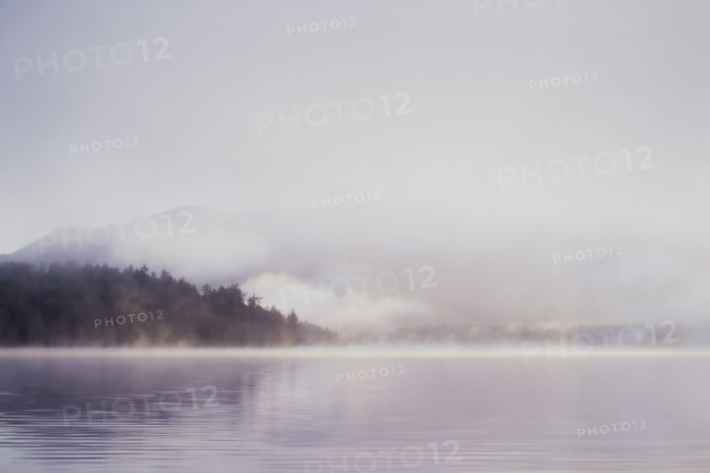 Morning mist rising over calm Lake Placid 
St. Armand, New York, USA