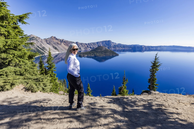 USA, Oregon, Portrait of smiling woman near calm Crater lake