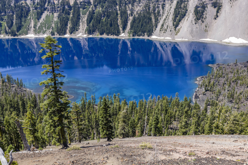 USA, Oregon, Cliffs reflected in calm surface of Crater lake