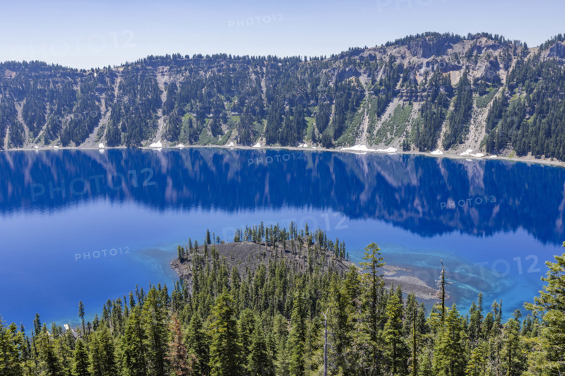 USA, Oregon, Cliffs reflected in calm surface of Crater lake