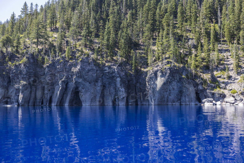 USA, Oregon, Cliffs with caves by calm Crater lake