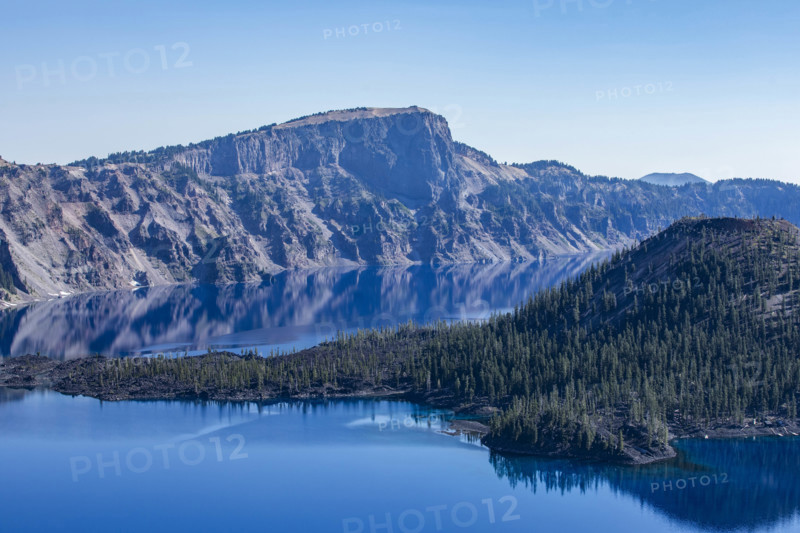 USA, Oregon, Cliffs reflected in calm surface of Crater lake
