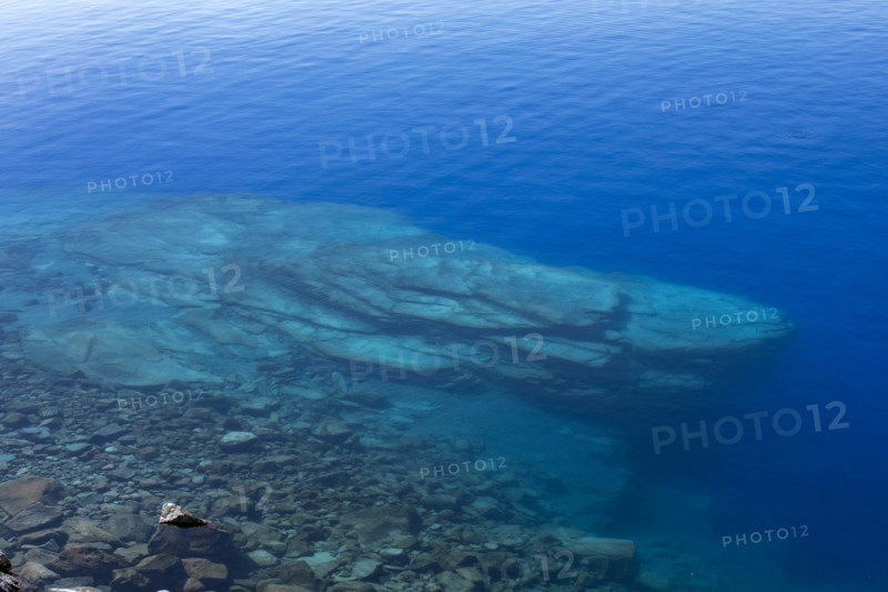 USA, Oregon, Rocks in blue calm Crater Lake