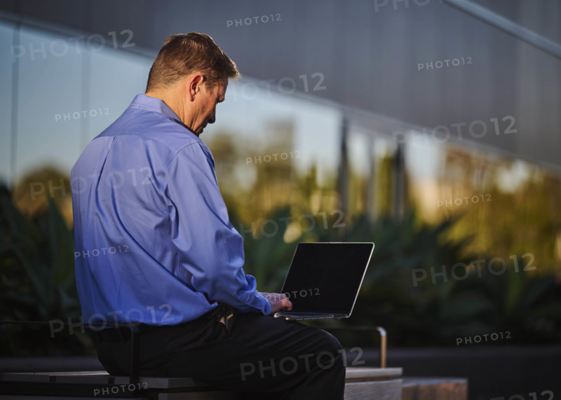 Man working on laptop outdoors