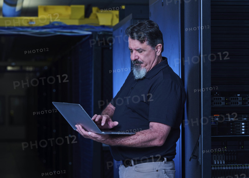 Man using laptop in data center