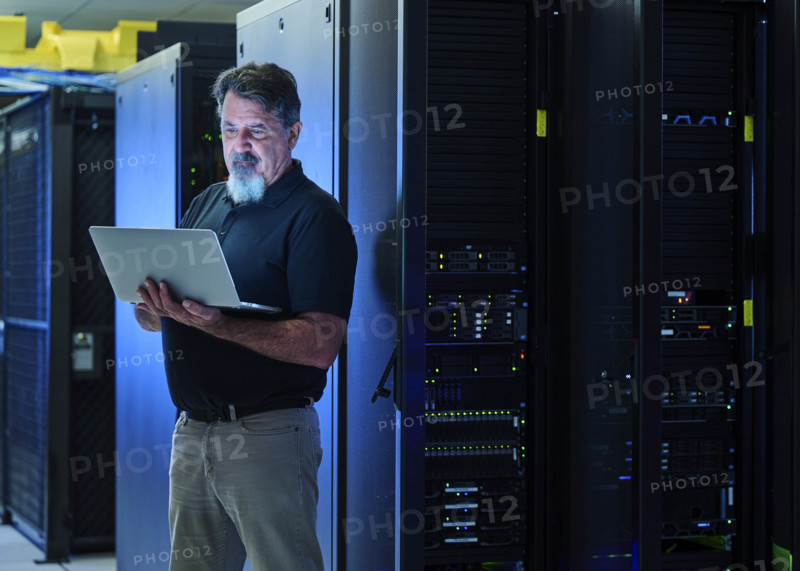Man using laptop in data center