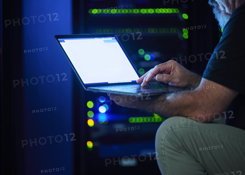 Close-up of man using laptop in data center