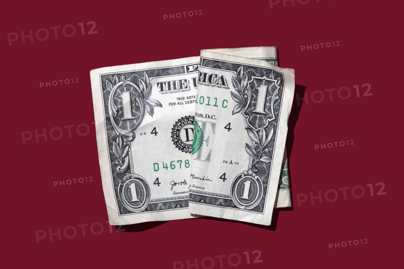 Studio shot of folded one dollar bill on red background