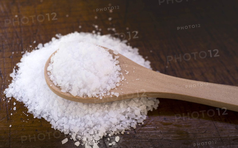 White coarse salt on wooden kitchen spoon