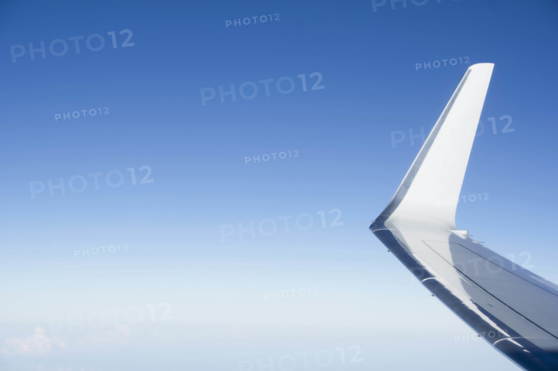 Jet airplane wing against clear blue sky