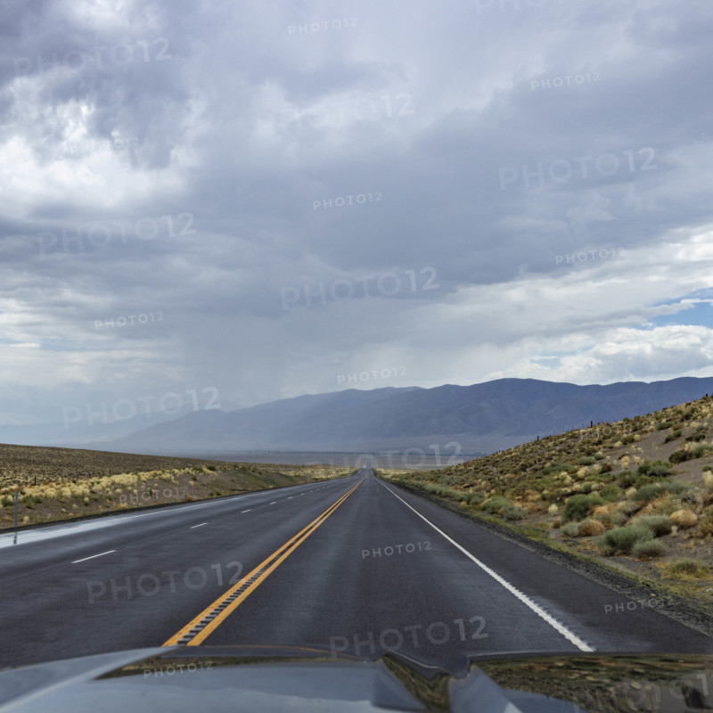 USA, Nevada, Winnemucca, Empty road and storm clouds seen from car