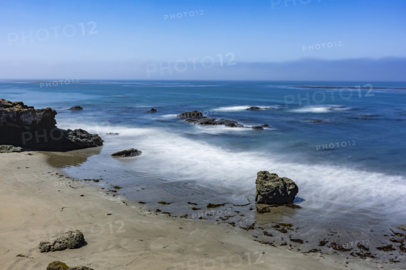 USA, California, San Simeon, Ocean waves washing sandy beach, long exposure