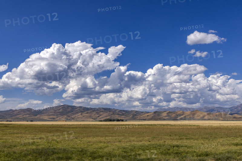 USA, Idaho, Fairfield, White puffy clouds above hills and grassy field