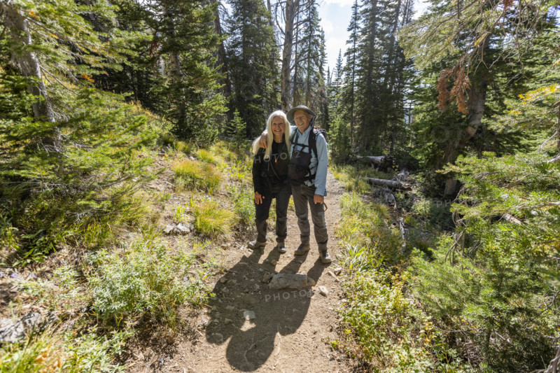 USA, Idaho, Sun Valley, Portrait of smiling senior couple standing on footpath in forest