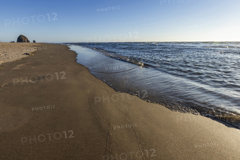 USA, Oregon, Cannon Beach, Empty beach with haystack rock in distance