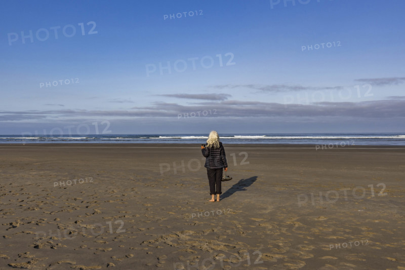 USA, Oregon, Newport, Rear view of woman standing on empty beach