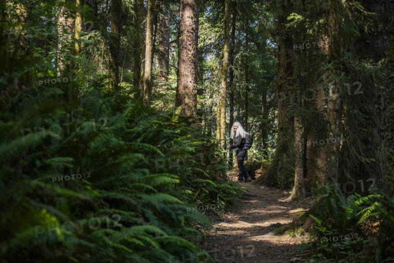 USA, Oregon, Brookings, Portrait of senior blonde hiker on coastal trail