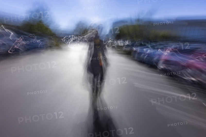 Motion blur image of woman walking in parking lot