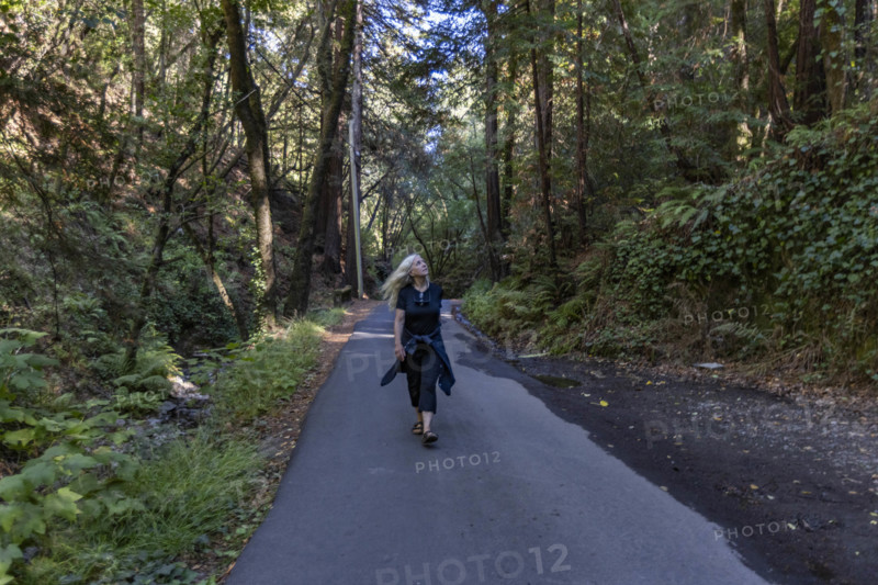 USA, California, Mill Valley, Woman walking on paved pathway in forest