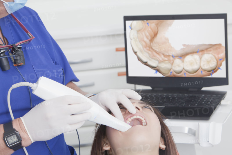 Dentist scanning female patients teeth with 3D scanner