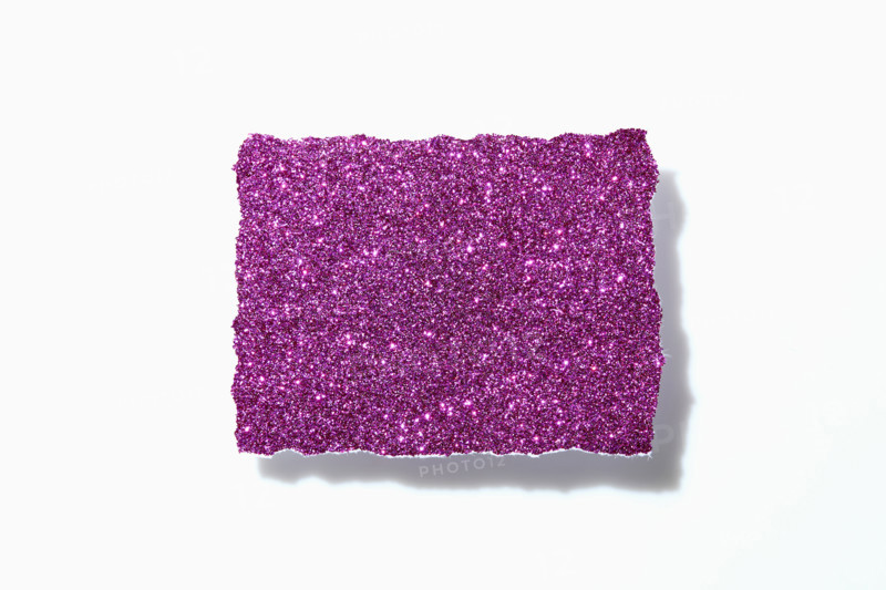 Torn pink glitter paper on white background