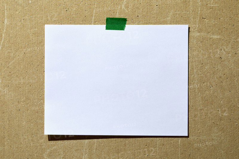 Blank paper taped to rough textured wall