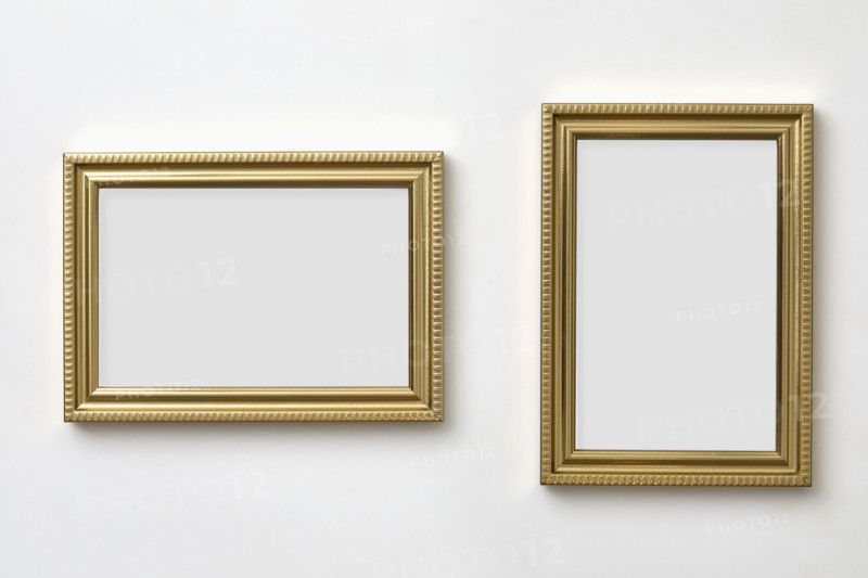 Gold decorative picture frames on white wall