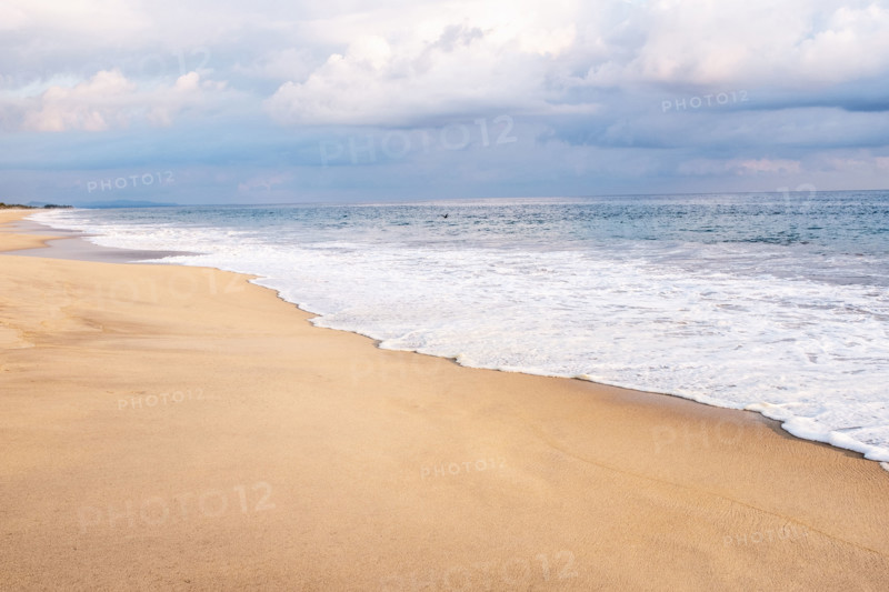 Mexico, Oaxaca State, Puerto Escondido, Costa Chica, Clouds overs ocean waves on empty beach