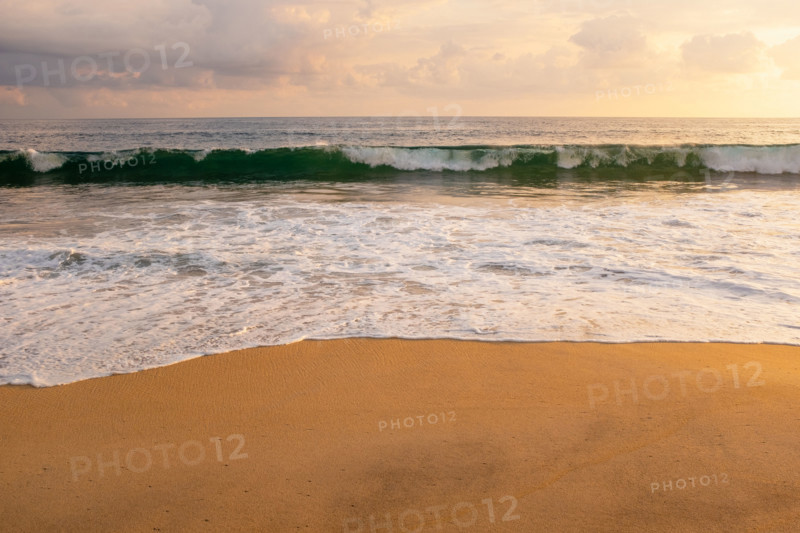 Mexico, Oaxaca State, Puerto Escondido, Costa Chica, Clouds over ocean waves on empty beach at sunset