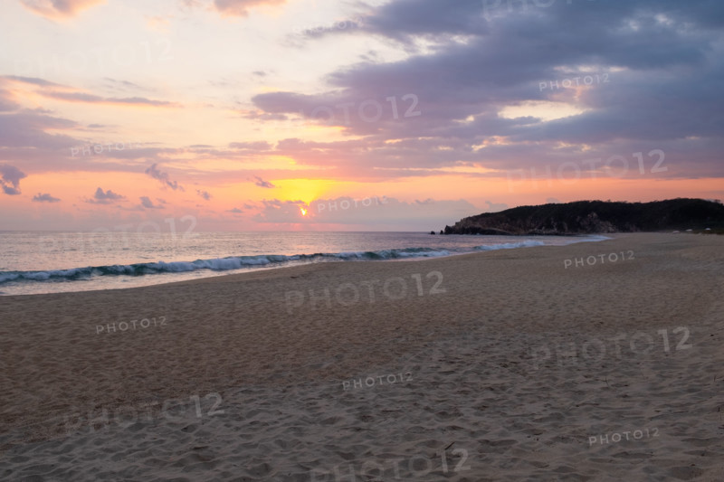 Mexico, Oaxaca State, Puerto Escondido, Costa Chica, Sun setting over ocean and empty beach