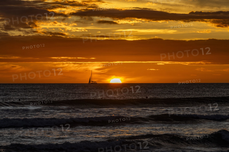 Costa Rica, Guanacaste, Playa Grande, Silhouette of sailboat on sea horizon at sunset