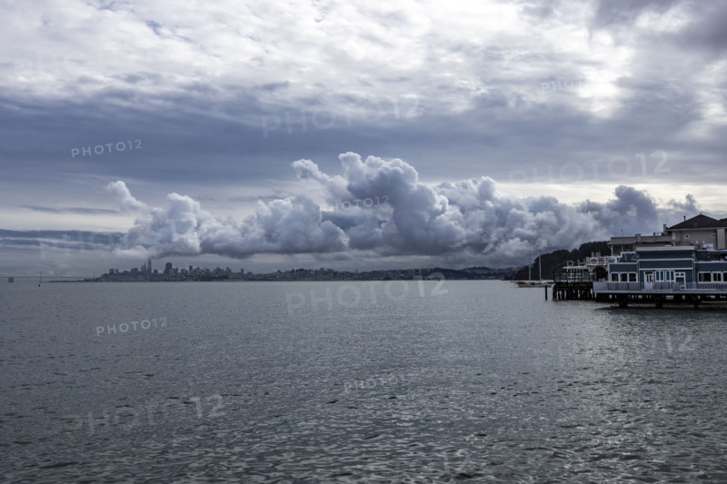USA, California, Sausalito, Puffy clouds above city skyline across bay
