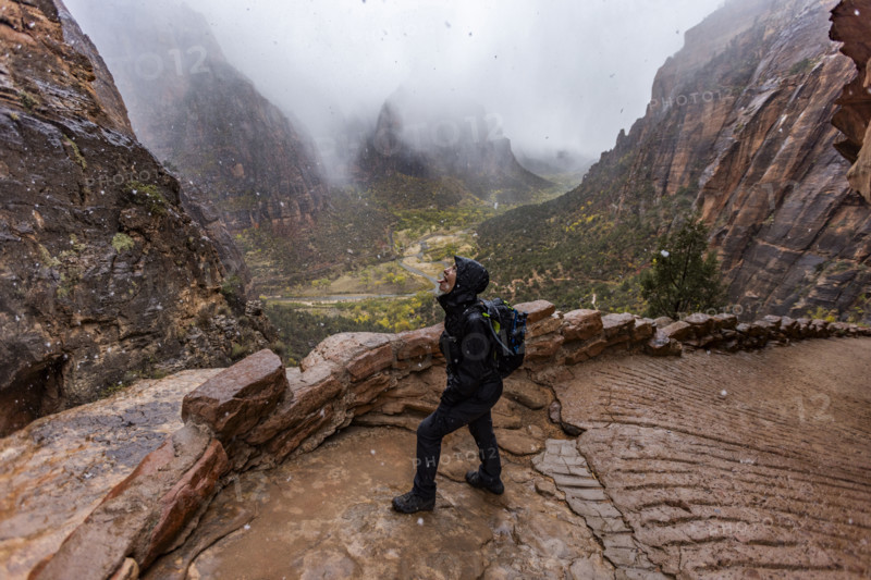 USA, Utah, Zion National Park, Female hiker catching snowflakes on tongue on trail to Angels Landing