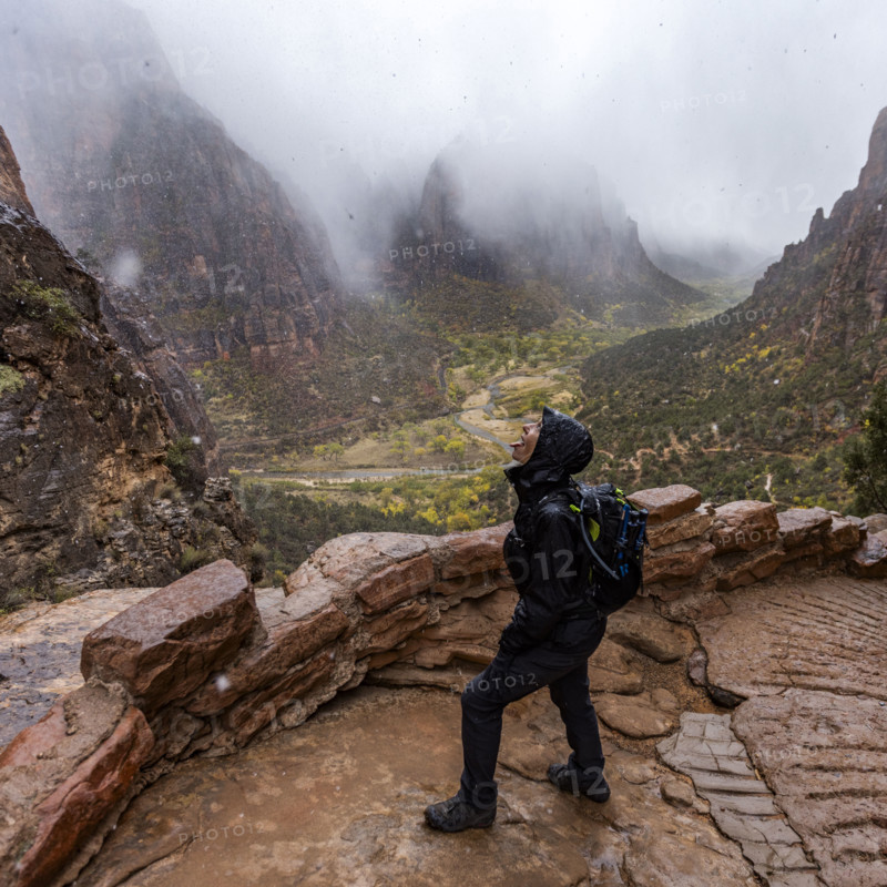USA, Utah, Zion National Park, Female hiker catching snowflakes on tongue on trail to Angels Landing
